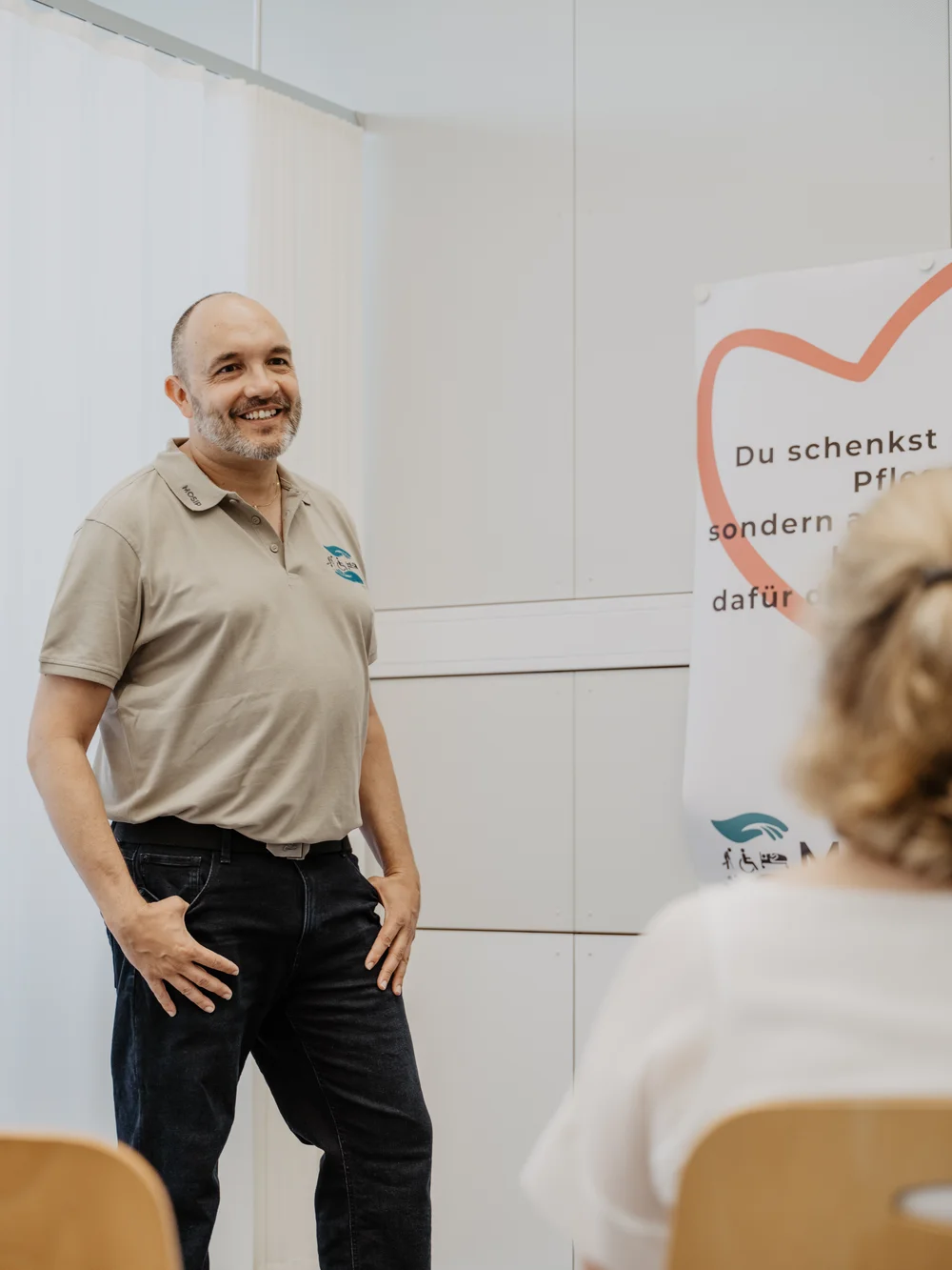 Roland Widmer spricht mit einer Teilnehmerin im Trainingsraum.