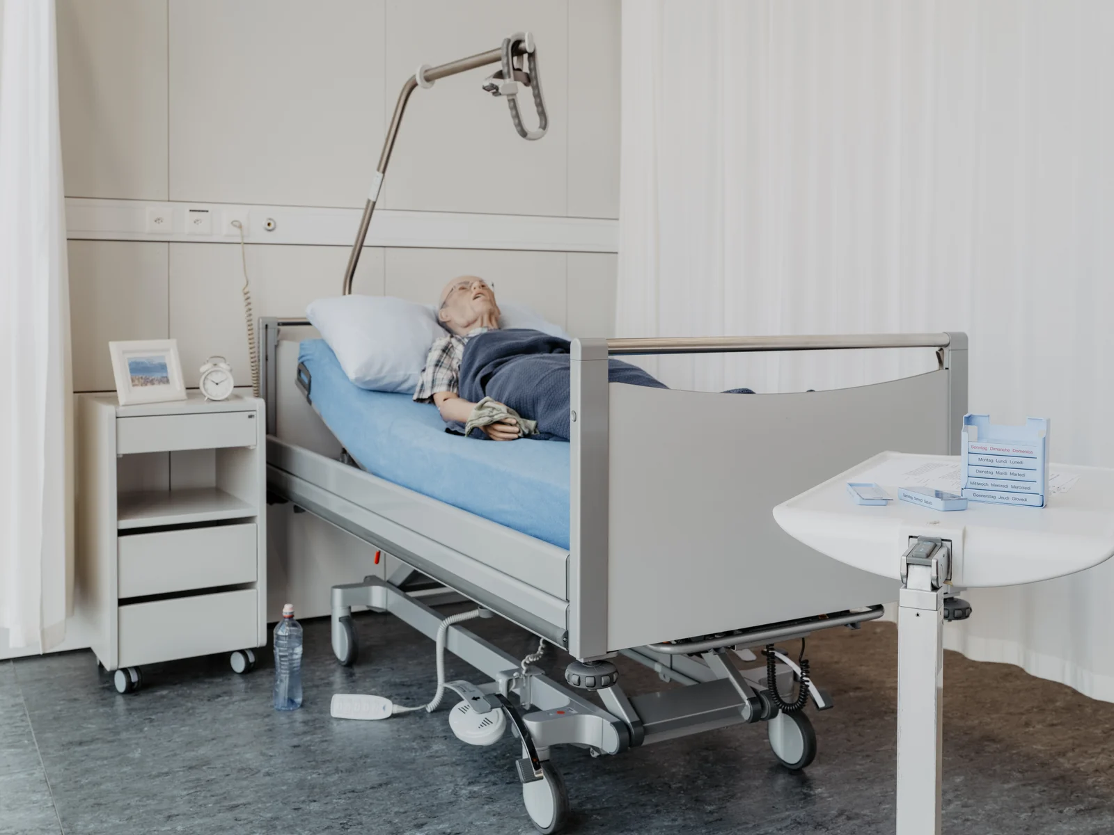 Eingerichteter Trainingsraum mit Pflegebett, Pflegepuppe und alltäglichen Hilfsmitteln.